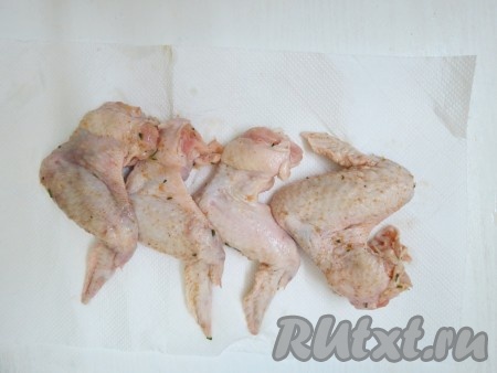 По истечении времени вынимаем куриные крылышки из ёмкости, снимаем зелень и вытираем крылышки бумажным полотенцем от влаги. Если не вытереть, тогда во время жарки будет много брызг, которые запачкают и вас, и кухню.
