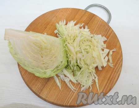 Капусту нарезаем на тонкие полоски. Наливаем в кастрюлю 2 литра воды, доводим до кипения. Кладём капусту в кипящую воду и варим 5 минут на среднем огне.