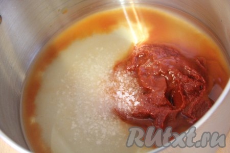 В большую кастрюлю (я готовила салат из кабачков в кастрюле объёмом 7 литров) влить воду, добавить томатную пасту, сахар, соль. Всё перемешать и поставить на огонь.