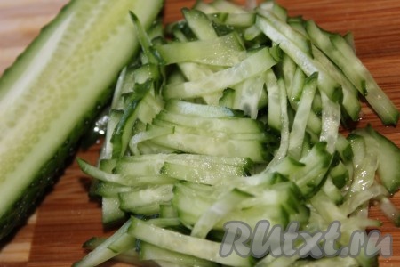 Тонкой соломкой нарезать вымытые огурцы.

