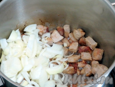 Лук очищаем, нарезаем четверть кольцами и добавляем к свинине.