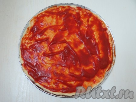 Отдельно томатную пасту разводим водой (соотношение пасты и воды должно быть 1 к 1). Смазываем тесто разведённой томатной пастой. Вместо томатной пасты, разведённой водой, можно использовать томатный соус.