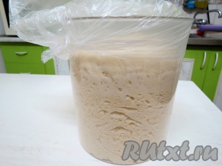 Поставьте тесто в тёплое место. Я ставлю в шкафчик. Приблизительно через час тесто увеличится в объёме в 2 раза. Выложите его на стол, обомните (выпустите из него воздух).