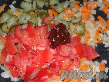 Помидоры и огурцы нарезать на небольшие кусочки и добавить к моркови с луком вместе с томатной пастой, перемешать и обжаривать 7-8 минут на небольшом огне, иногда помешивая.
