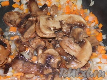 Грибы вымыть, нарезать на тонкие пластинки и добавить к обжаренной моркови и луку, потомить на маленьком огне, помешивая, минут 5-10 и переложить зажарку в куриный бульон.
