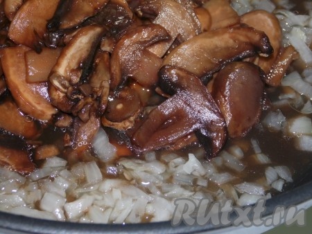 Очищенный репчатый лук нарезать маленькими кубиками и обжарить на растительном масле, помешивая, до лёгкого румянца. Мелко нарезанные грибы добавить к обжаренному луку и готовить, помешивая, на маленьком огне в течение 7-10 минут.
