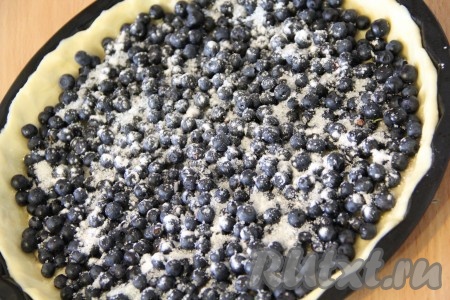Ягоды вымыть под проточной водой, откинуть на дуршлаг, чтобы стекла лишняя вода. Если ягоды замороженные, их нужно разморозить и слить лишнюю жидкость. Затем выложить ягоды на тесто, разровнять и присыпать крахмалом.