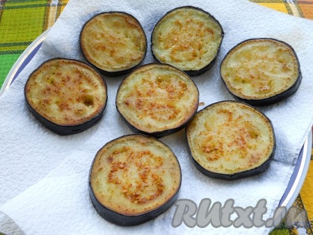 Затем баклажаны обсушить салфеткой и обжарить на подсолнечном масле до румяности с двух сторон. Выложить баклажаны на салфетку для удаления лишнего жира.
