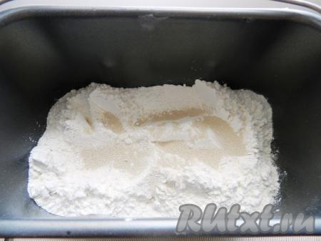 В контейнер хлебопечки всыпьте муку, выложите сахар, соль и сухие дрожжи. Дрожжи и соль не должны быть рядом, так как соль мешает дрожжам раскрыться. Я соль всыпаю в угол, а дрожжи высыпаю в центр.