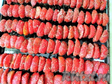 На противень выкладываем решётку, а на неё - помидоры, спинками вверх. Оставляем их на 2 часа, чтобы под воздействием соли и сахара ушла лишняя влага.
