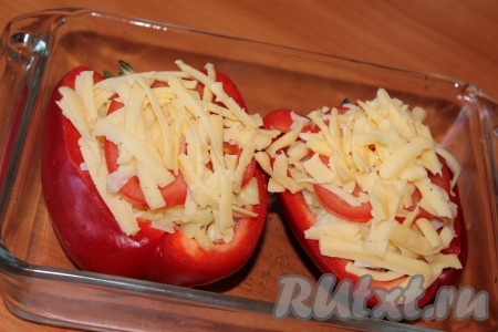 Жаропрочную форму слегка смазать растительным маслом. Добавить 2-3 столовые ложки воды. Выложить фаршированный перец, посыпать сыром. Запекать половинки перца в разогретой духовке при температуре 180 градусов в течение 30-35 минут.
