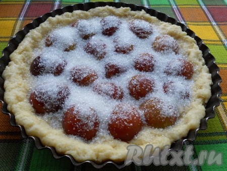 Сливы вымыть, разрезать пополам, удалить косточки и на внешней стороне половинок сделать по несколько надрезов, не дорезая до конца сливы. На тесто выложить плотно друг к другу подготовленные половинки слив, немного вдавливая их. Сверху посыпать пирог 0,5 стакана сахара.