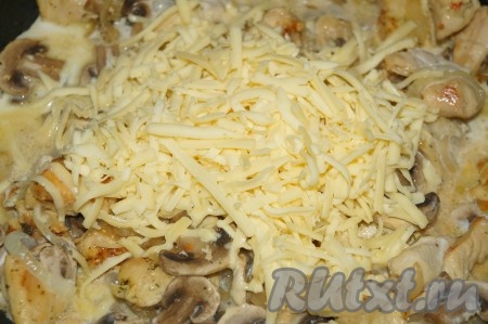 К куриному филе, обжаренному с грибами, добавить сливки и сыр, натёртый на крупной тёрке, перемешать и томить под крышкой на минимальном огне минут 15-20, не забывая иногда помешивать. Если нужно, в процессе томления досолить соус по вкусу. Убрать готовое блюдо с огня.