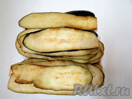 Баклажаны нарезаем вдоль тонкими слайсами. Слегка солим и отставляем в сторону на полчаса, чтобы ушла горечь. Через полчаса удаляем выделившуюся влагу бумажным полотенцем.
