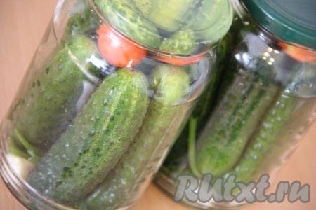 Затем плотно утрамбовать в каждую банку огурцы. При желании сверху можно добавить несколько вымытых помидоров черри - но это необязательно. Прикрыть банки крышками.