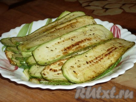 На каждый кабачковый слайс выложить понемногу обжаренных моркови и лука, свернуть рулетиком. Получится много рулетиков из кабачков.
