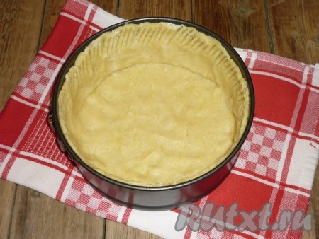 Дно формы для выпечки (у меня форма диаметром 20 сантиметров) застелить пергаментной бумагой. Охлаждённое тесто раскатать, выложить в форму для выпечки, формируя из теста бортики.