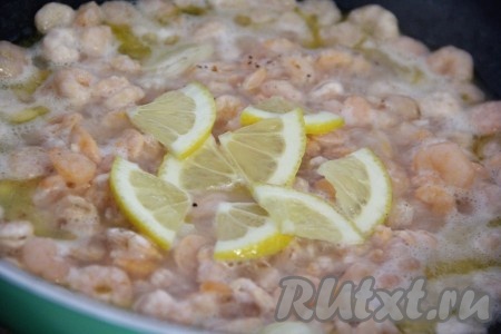 Лимон хорошо вымыть. 2 кружочка лимона нарезать на четвертинки. Из оставшейся части лимона выдавить сок. Добавить в креветки сок и дольки лимона, посолить и хорошо перемешать.