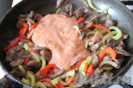 Отдельно в миске смешать томатную пасту и сметану, выложить в сковороду с куриными сердечками и овощами, перемешать, влить воду, посолить, поперчить, снова перемешать. Дать томатно-сметанному соусу закипеть, уменьшить огонь и тушить сердечки под крышкой на небольшом огне минут 20-25 (до мягкости сердечек).