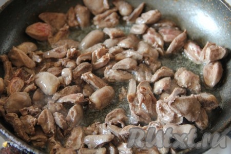 Куриные сердечки очистить от плёночек и жира. Разрезать сердечки пополам, промыть тщательно водой, убирая сгустки крови. В сковороде разогреть растительное масло, выложить куриные сердечки, обжаривать их под крышкой 10 минут на огне ниже среднего, периодически перемешивая.