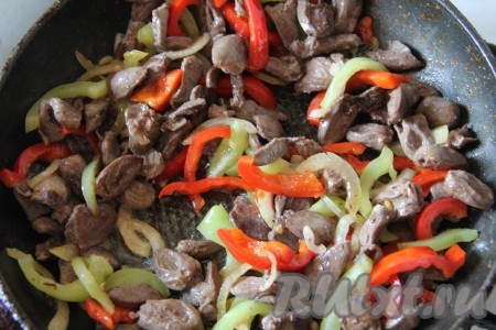 В сковороду с обжаренными овощами добавить обжаренные куриные сердечки, перемешать.