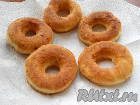 Готовые творожные пончики выкладывать со сковороды на бумажные салфетки для удаления лишнего жира. Постепенно пожарить все пончики.