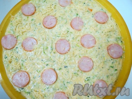 Форму смазываем сливочным маслом. Приготовленное кабачковое тесто выливаем в форму. Выкладываем на него колбасу.
