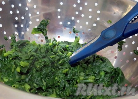 Шпинат моем, заливаем двумя литрами кипятка и отвариваем в течение 4 минут. Откидываем на дуршлаг и на нём нарезаем ножницами. Тщательно выдавливаем воду.

