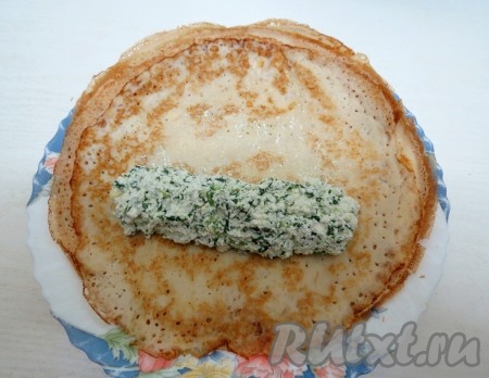 На блин выкладываем 2 столовые ложки начинки, скатываем блин, боковые части заправляем внутрь.