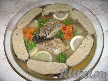 Если вы захотите приготовить заливную фаршированную рыбу, тогда тушите не 1,5, а 2,5 часа, затем охладите, нарежьте на кусочки и залейте водичкой, в которой рыба тушилась (если вы планируете изначально готовить заливную фаршированную рыбу, то на противень надо наливать воды столько, чтобы она покрыла рыбу). Так выглядит рыба заливная. Заливкой послужил отвар, в котором готовили рыбу. Он прекрасно желируется, за счёт костей и чешуи.
