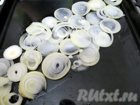 Противень смазываем растительным маслом, на противень нарезаем колечки лука и выстилаем их в форме рыбы.