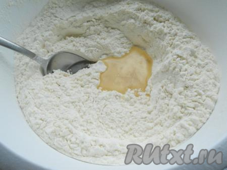 Для того чтобы замесить тесто, нужно в глубокую миску просеять муку, добавить соль, сахар и сухие дрожжи, перемешать. Сделать в муке углубление по середине и влить туда растительное масло.