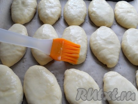 Сформированный пирожок с мясом швом вниз выложить на противень, застеленный пергаментом. Аналогично сформировать и выложить швом вниз все пирожки. Яйцо в небольшой ёмкости хорошенько взбить вилкой (или венчиком). С помощью силиконовой кисточки яйцом смазать пирожки с мясом и поставить в разогретую духовку, выпекать минут 35-40 (до румяности дрожжевого теста) при температуре 180 градусов духовке. Продолжительность выпечки во многом зависит от особенностей вашей духовки.