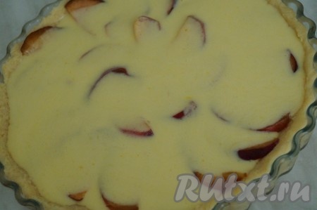 Вылить сметанную заливку на персики, выложенные на песочное тесто.