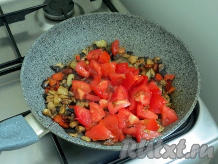 Помидоры нарезаем небольшими кусочками и добавляем их в сковороду, перемешиваем и обжариваем 2-3 минуты. Солим, но очень осторожно, учитывая то, что в состав начинки будет входить твёрдый сыр, а он солёный.
