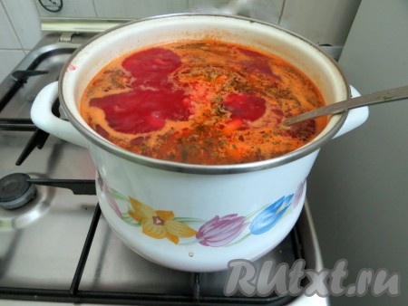 Затем в кастрюлю отправляем обжаренные овощи, солим, перчим. Даём борщу закипеть, провариваем его 3-5 минут на небольшом огне, затем добавляем мелко нарезанные чеснок и зелень, даём закипеть и снимаем с огня.