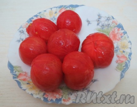Помидоры надрезаем крест на крест, опускаем их на минуту в кипяток, затем аккуратно достаём из воды и снимаем кожицу. 