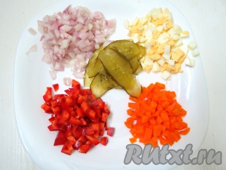 Приступаем к приготовлению начинки. Морковь предварительно отвариваем в кожуре до готовности (в течение 25-30 минут после начала кипения воды), затем даём остыть и очищаем. Яйцо отвариваем в течение 10 минут после закипания воды, затем даём остыть и очищаем. Болгарский перец очищаем от семечек и плодоножки. Луковицу очищаем. Лук, морковь, яйцо, перец нарезаем на мелкие кубики. Огурцы нарезаем вдоль на тонкие пластины.