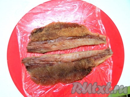 Выкладываем филе на пищевую плёнку. У нас попалась сельдь с икрой. Икру тоже можно использовать для приготовления этой закуски. Икру разрезаем вдоль и выкладываем на сельдь.
