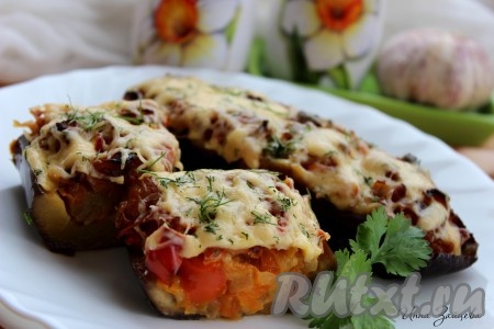 За 10 минут до окончания запекания посыпать "лодочки" оставшимся сыром. Готовность блюда можно проверить, проткнув баклажаны зубочисткой (они не &nbsp;должны быть жесткими). Перед подачей на стол сочные, вкусные баклажаны, фаршированные овощами, посыпать мелко рубленной зеленью.
