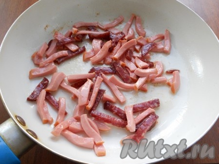 Колбасу вареную и полукопченую нарезать соломкой, поместить в сковороду. Добавить оставшееся сливочное масло и обжарить колбасу в течение 2-3 минут.
