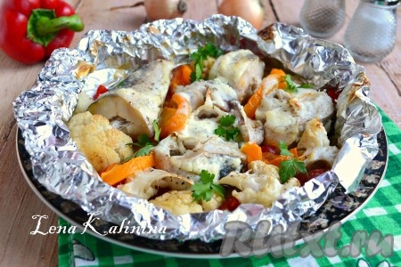 Фольгу подогнуть, сделав как бы чашу. Запекать хека с овощами в предварительно разогретой до 180 градусов духовке около 35-40 минут (ориентируйтесь по своей духовке). Готовую рыбу с овощами посыпать измельченной зеленью.