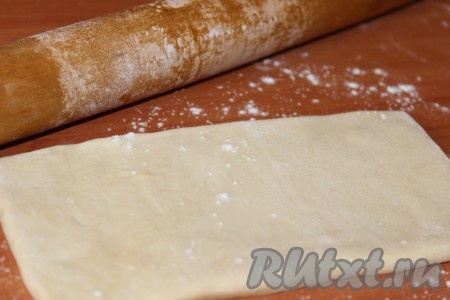 Наша начинка готова. Приступаем к формовке изделий. Рабочую поверхность присыпать мукой и выложить размороженное слоеное тесто. Затем разделить его на равные части (я использовала готовые квадратные пластинки слоеного теста).
