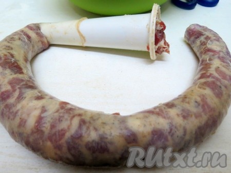 Для наполнения кишок нам понадобится конус в форме трубочки. Можно заполнять кишки вручную, можно конус прикрепить к мясорубке, но мы делали вручную. На конус натягиваем как можно больше кишки и широкий конец заполняем мясом, проталкивая его пальцем. Если вдруг обнаружите разрыв на кишке, просто на месте разрыва разрежьте кишку, тогда колбаски будут более короткими. Если у вас нет конуса, тогда обрежьте пластиковую бутылку в виде лейки (на 10-15 см вниз от горлышка).
