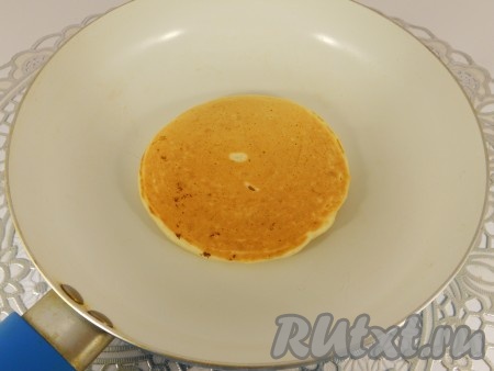 С помощью лопатки перевернуть блинчик на другую сторону и жарить также около минуты.