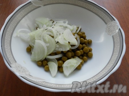 Консервированный горошек откинуть на дуршлаг, чтобы жидкость полностью стекла. Выложить горошек в глубокую посуду, добавить нарезанный тонкими полукольцами или перьями репчатый лук.