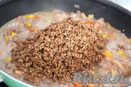 Далее влить бульон или воду и всё слегка перемешать. Затем всыпать гречневую крупу.