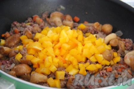 Перец очистить от семян и плодоножки. Нарезать перец мелким кубиком и добавить в сковороду. Всё хорошо перемешать и жарить 2-3 минуты.