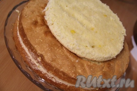 Накрыть крем вторым коржом и слегка прижать. Затем на середину коржа выложить небольшое количество крема и выложить маленький корж срезом вверх.