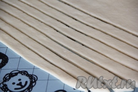 Вторую часть теста раскатать в пласт. С помощью ножа нарезать тесто на полоски шириной примерно 2-3 сантиметра.